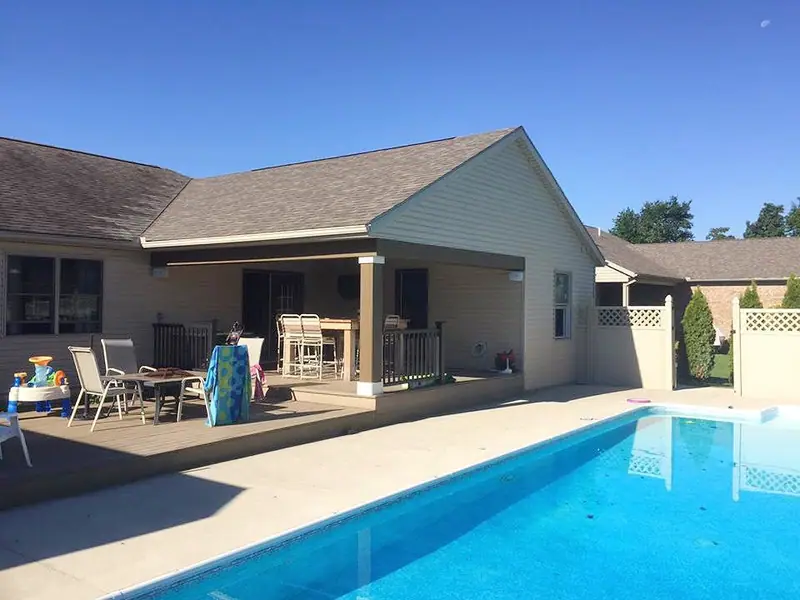 Home exterior with covered patio beside a pool