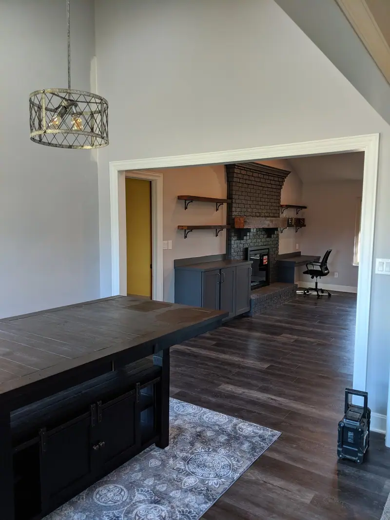 Home office with wood floors and floating shelves