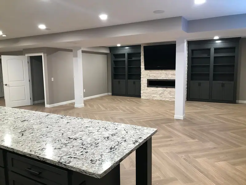Open finished basement with built-ins and herringbone floor