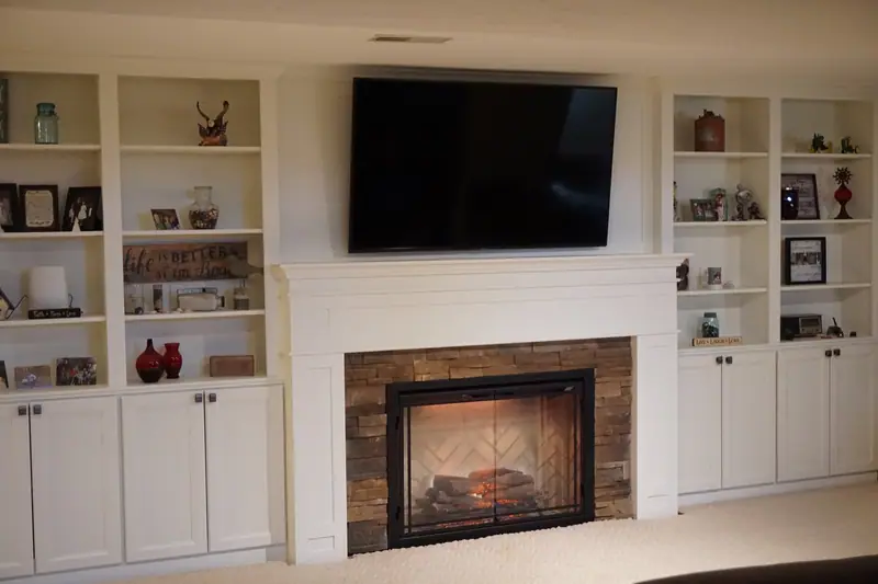 Fireplace with white built-in bookshelves on both sides