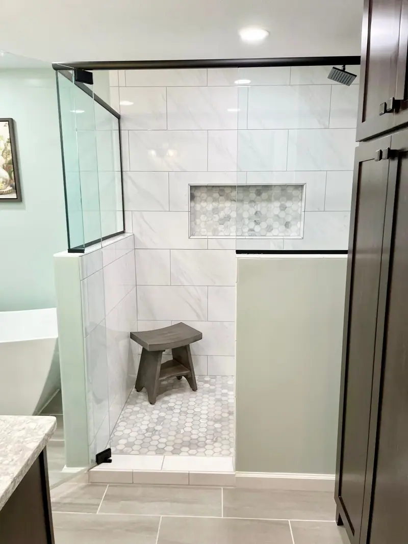 Walk-in tile shower with bench and decorative niche
