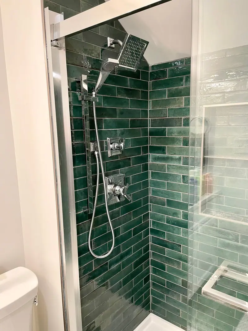 Shower with green glazed tile and brushed fixtures