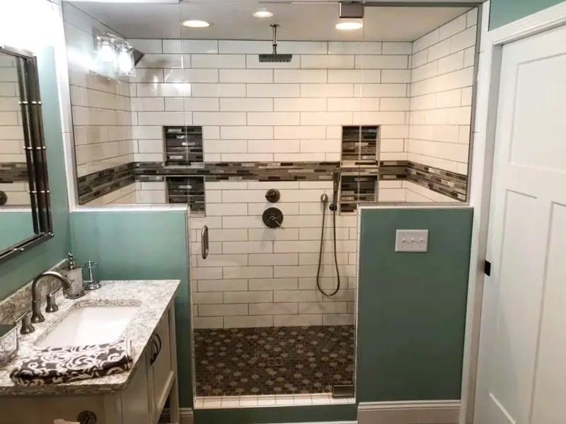 Subway tile shower with mosaic accent bands