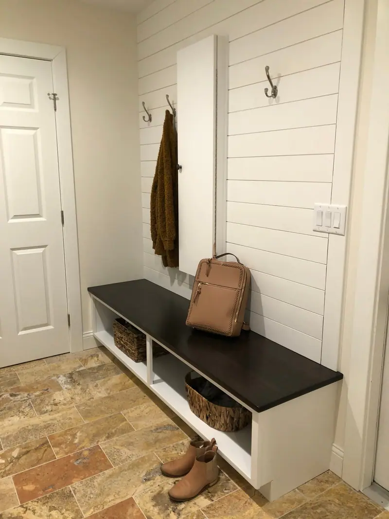 Mudroom bench with shiplap wall and coat hooks