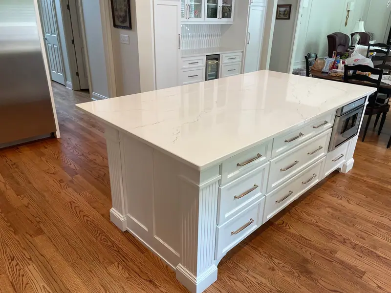 White kitchen island with quartz top and drawer storage