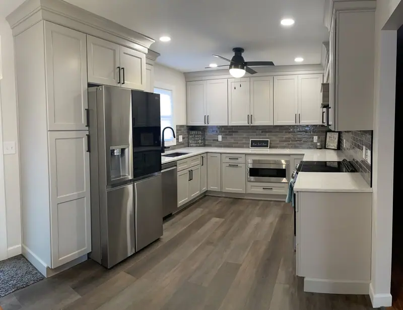 L-shaped white kitchen with stainless appliances