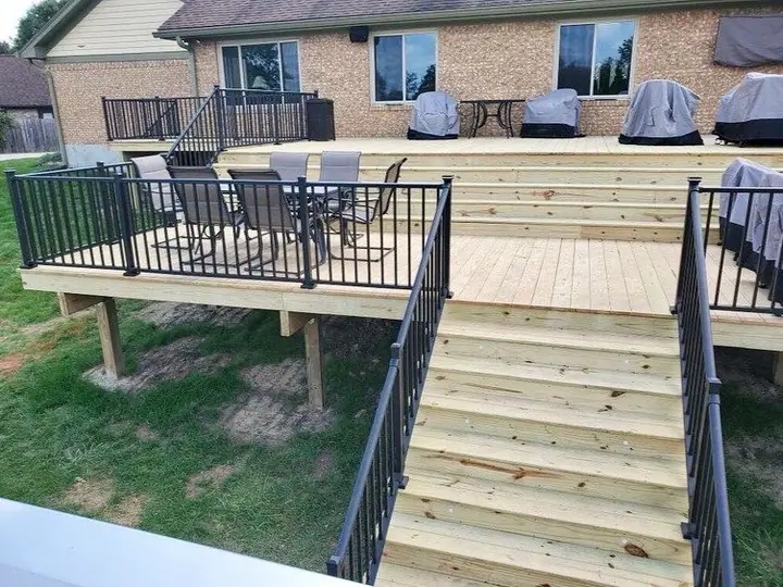Raised wood deck with black railings and stairs