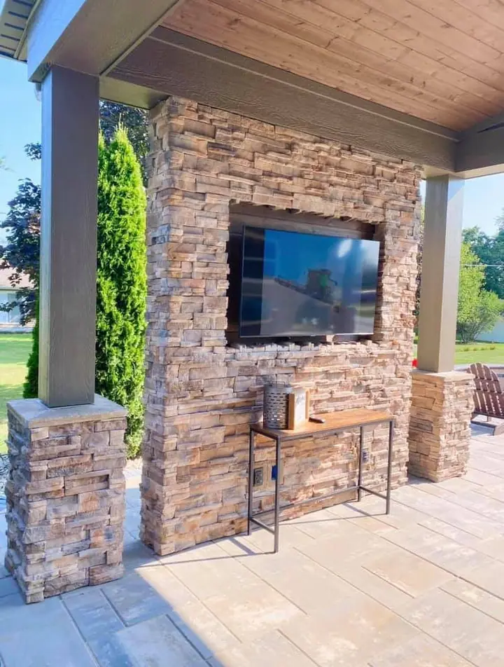 Stacked stone outdoor fireplace wall with television
