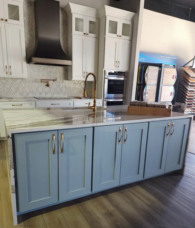 Showroom kitchen display with blue island and brass hardware